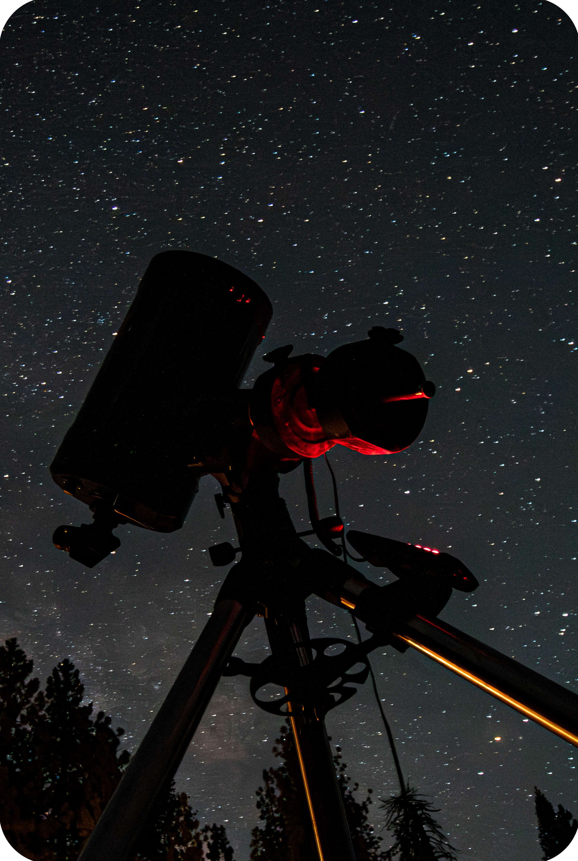 A telescope at night with stars in the background